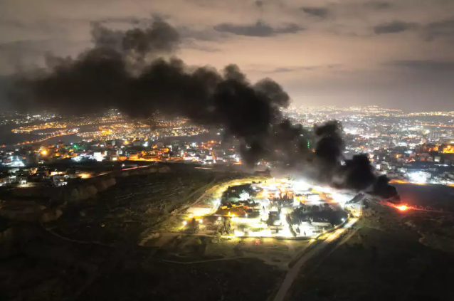 עשן שריפה בתוך עיר בלילה